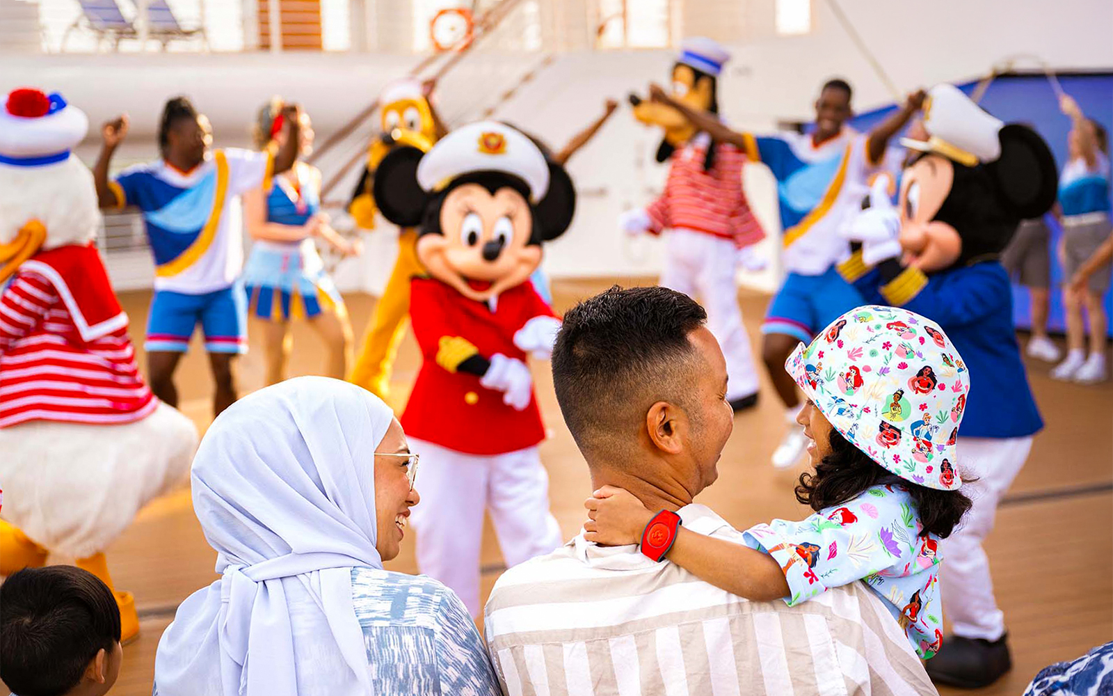 Family enjoying Disney characters at sail away party on Disney Adventure Cruise from Singapore.