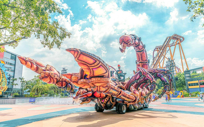 Giant scorpion-themed ride at Chimelong Paradise with roller coaster in background.