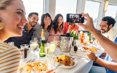 Guests enjoying brunch with mimosas on Newport Beach cruise.