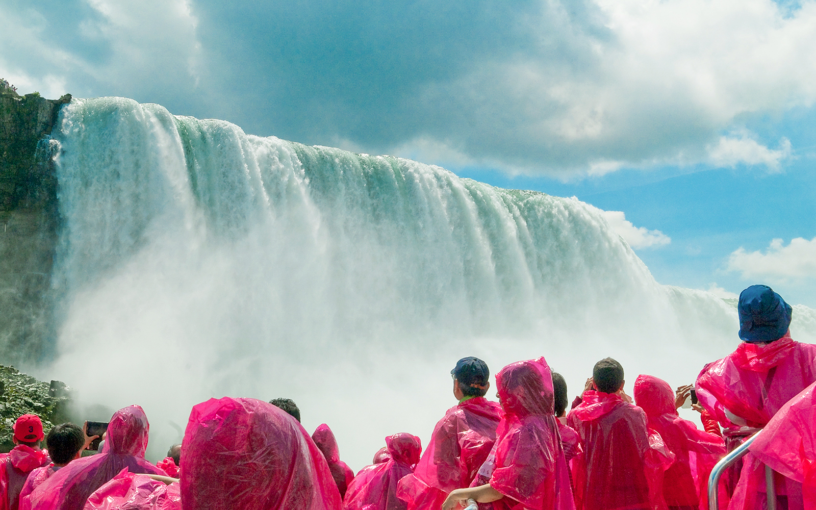 Tourists in pink ponchos on a boat cruise near Niagara Falls.
