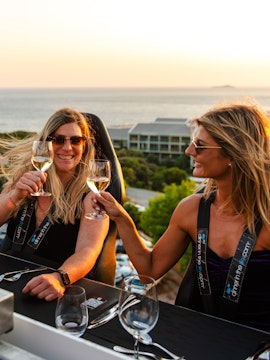 Guests toasting at Dinner in the Sky with a view of Dubrovnik coastline.