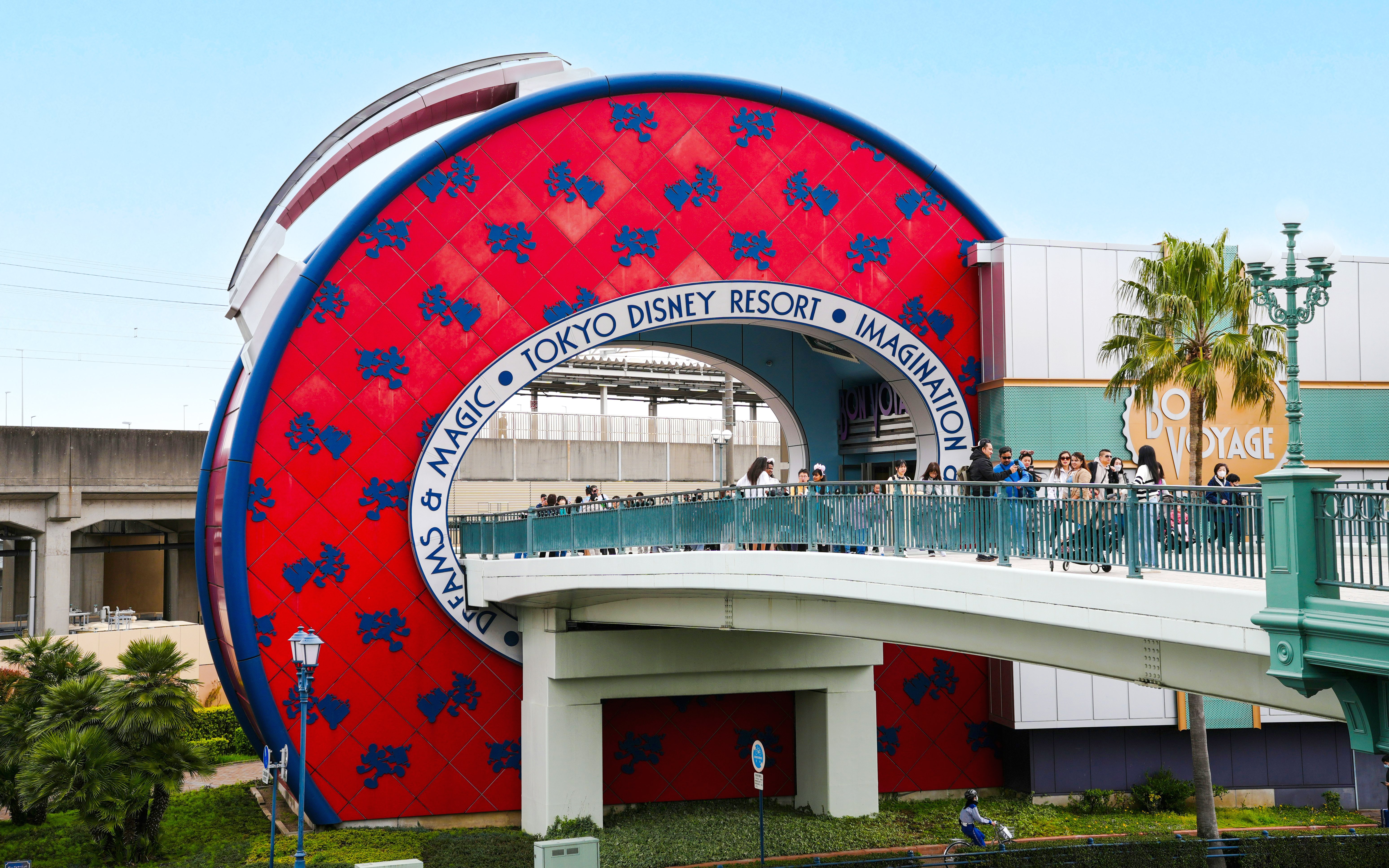 Entrance to Tokyo Disney Resort Japan with visitors on a bridge.