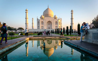 Taj Mahal at sunrise with reflection in water, Agra tour.