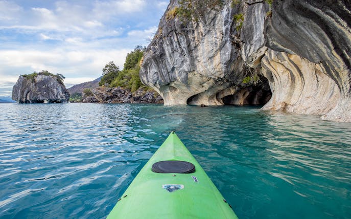 Kayak approaching rocky caves along Sorrento Coast on tour to Crapolla Fjord.