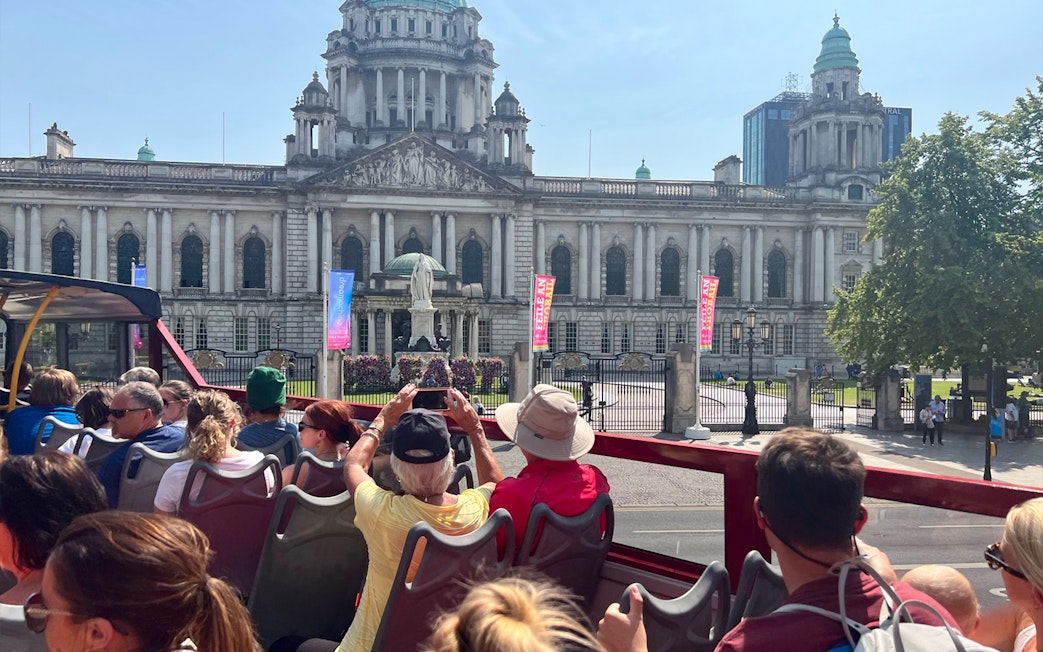 Open-top bus tour in front of Belfast City Hall.