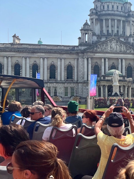 Open-top bus tour in front of Belfast City Hall.