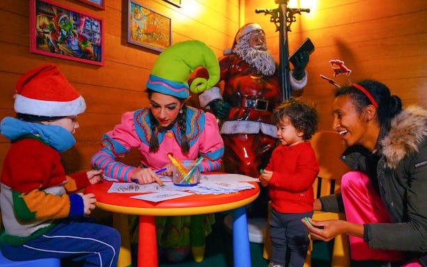 Children coloring with an elf at Gardaland Park, Italy.