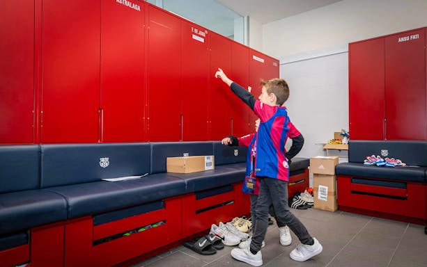 Child exploring FC Barcelona locker room during Players Experience tour.