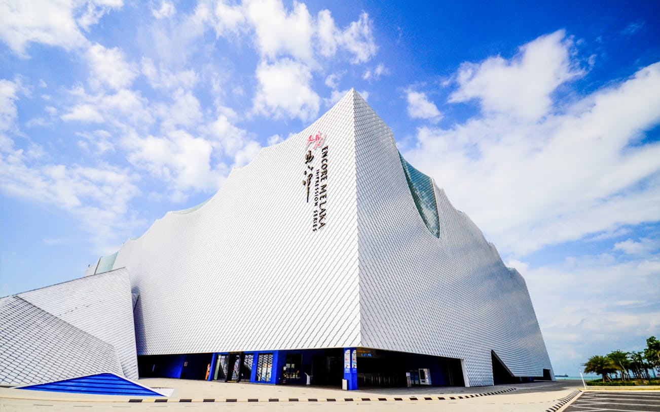 Encore Melaka theatre building with unique architecture under a blue sky.