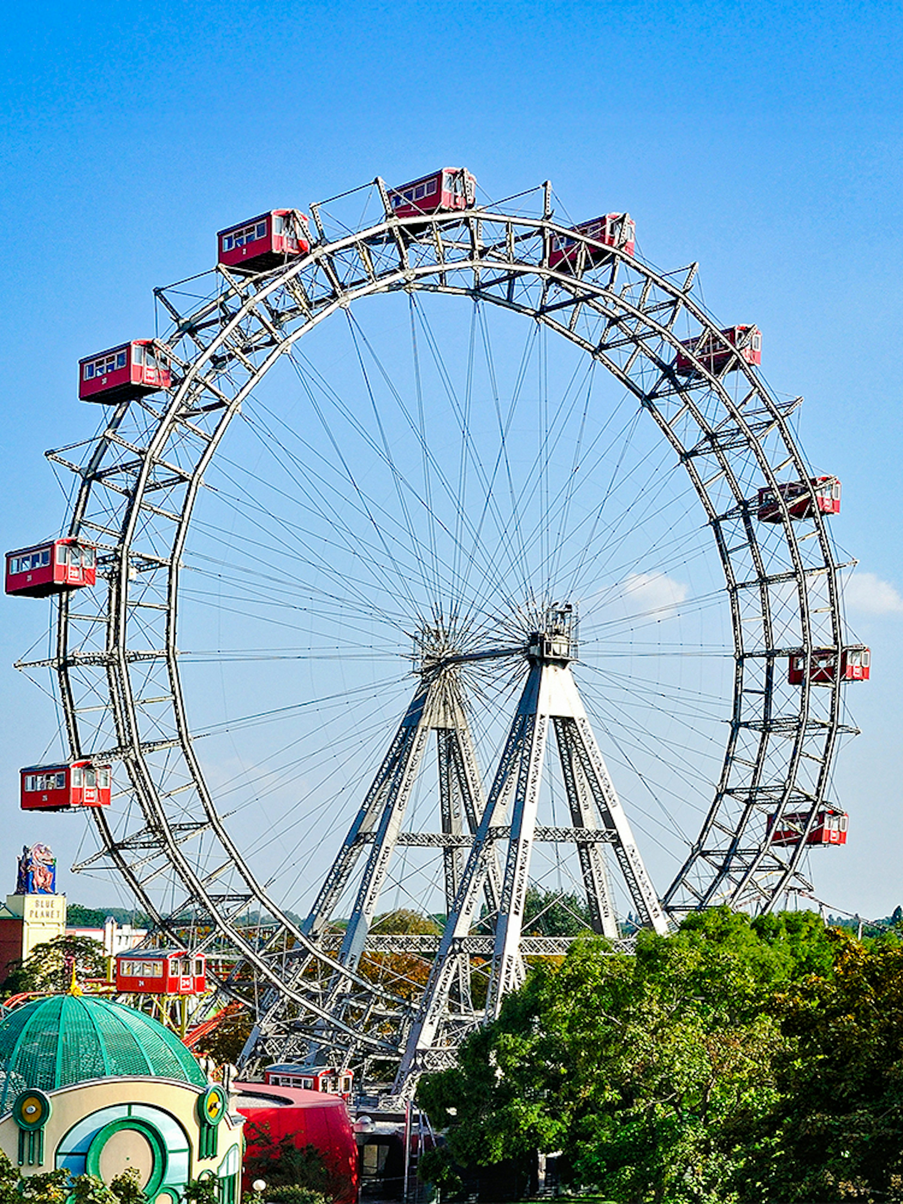 Vienna Giant Ferris Wheel with red cabins against a clear blue sky.