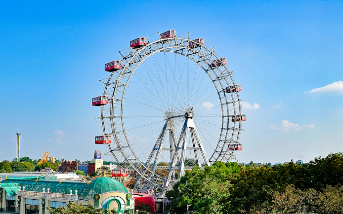 Vienna Giant Ferris Wheel with red cabins against a clear blue sky.