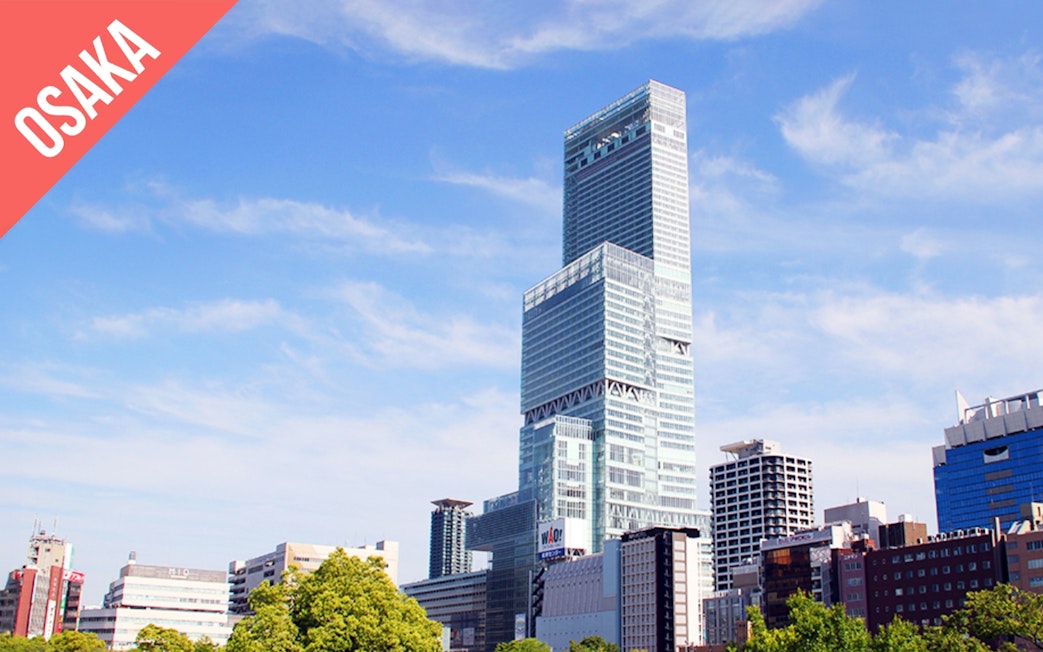 Abeno Harukas skyscraper in Osaka under a clear blue sky.