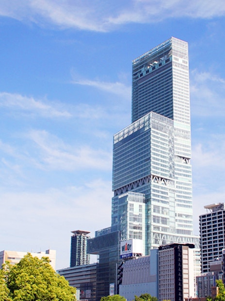 Abeno Harukas skyscraper in Osaka under a clear blue sky.