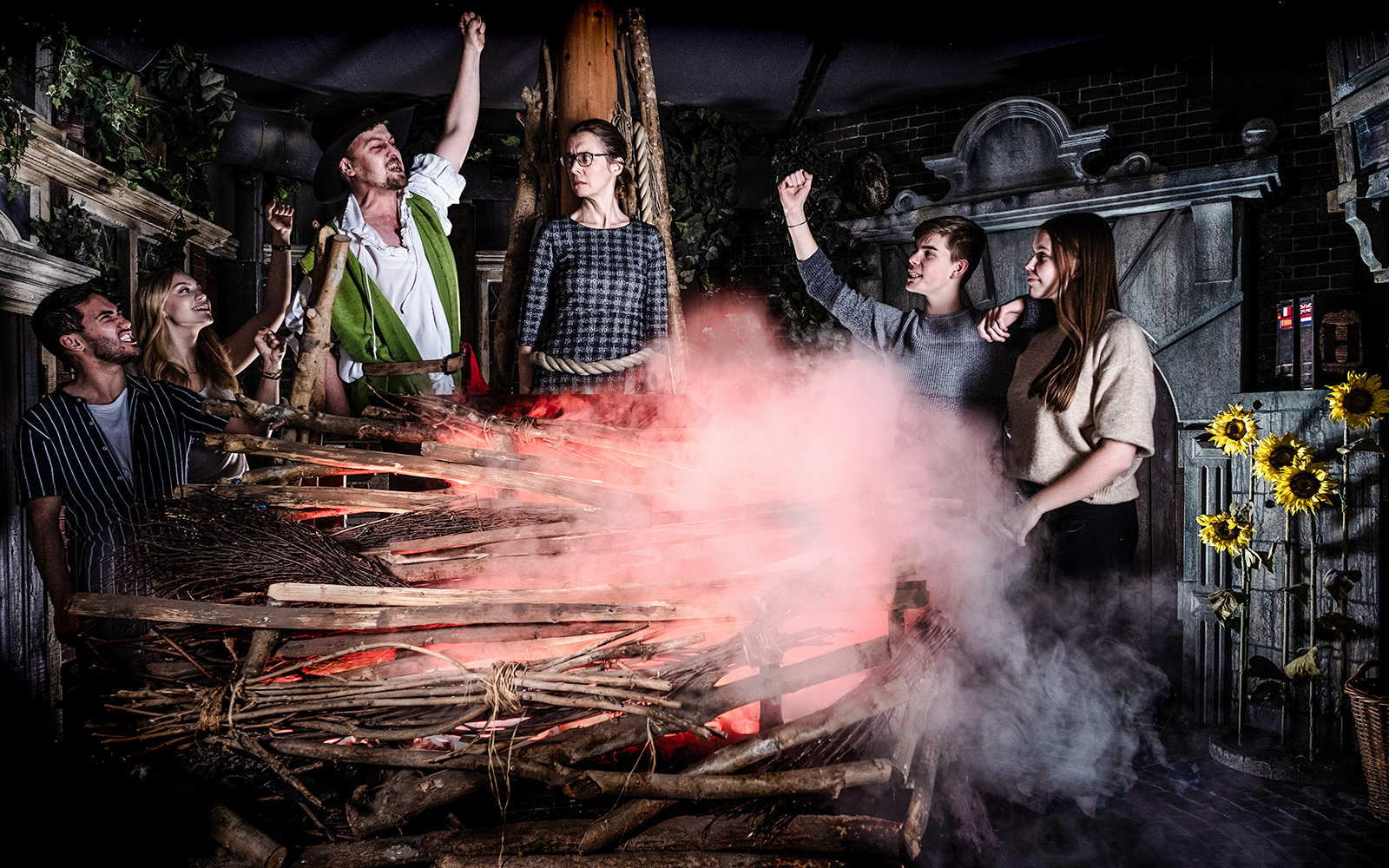 Guests experiencing a dramatic scene at the Amsterdam Dungeon with smoke and props.