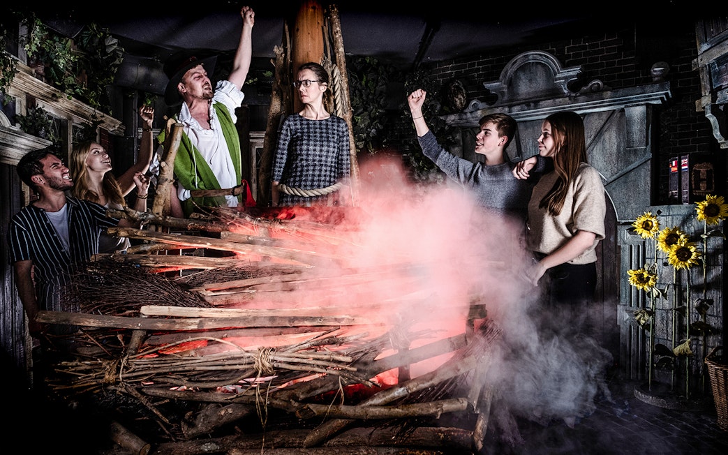 Guests experiencing a dramatic scene at the Amsterdam Dungeon with smoke and props.