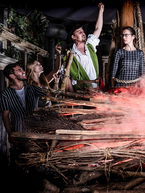 Guests experiencing a dramatic scene at the Amsterdam Dungeon with smoke and props.
