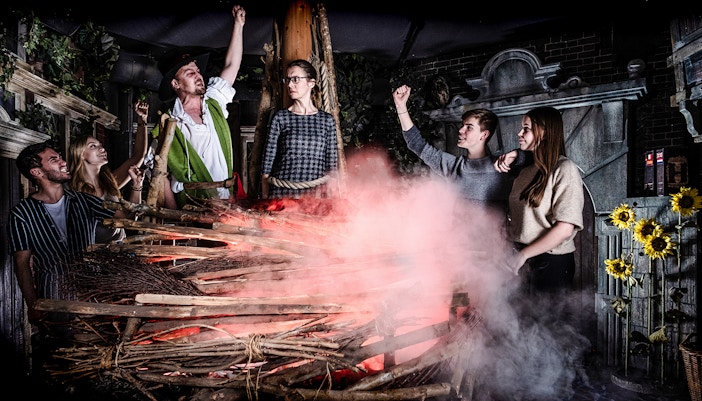 Guests experiencing a dramatic scene at the Amsterdam Dungeon with smoke and props.