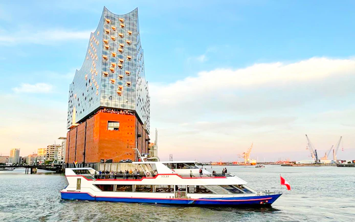 Tour boat passing Elbphilharmonie on Hamburg harbor tour.
