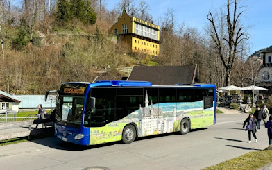 Bus near Hohenschwangau Castle with scenic mural, Germany.