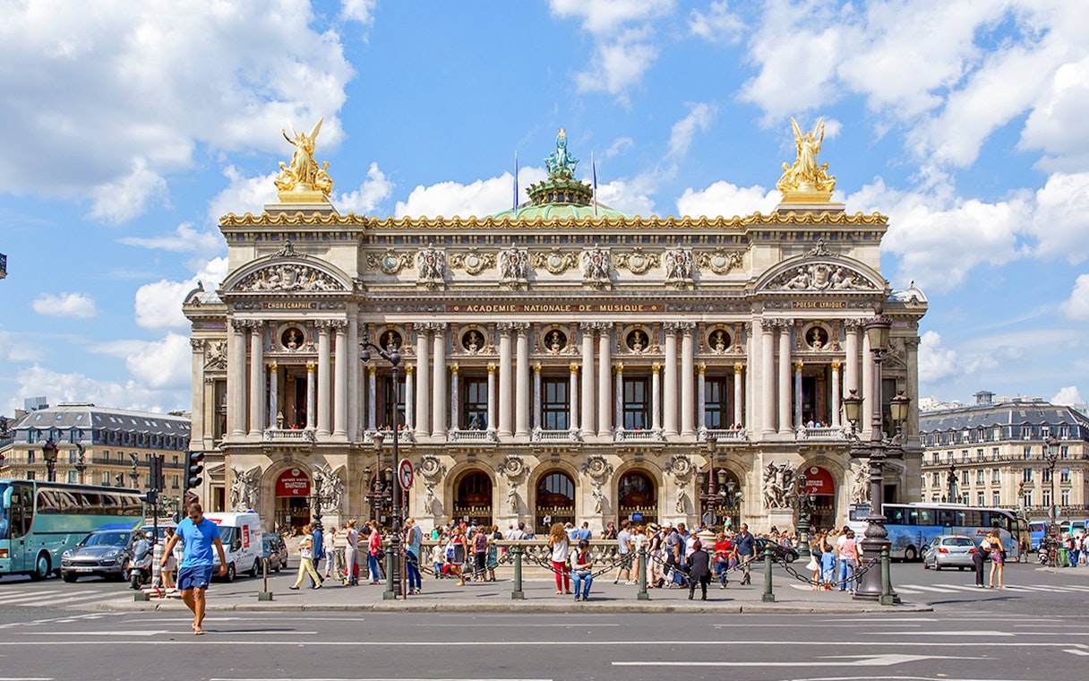 Opera Garnier in Paris with people walking and traffic in front.