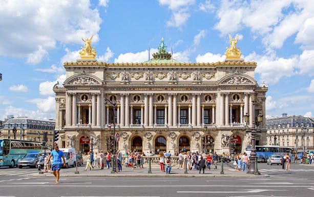 Opera Garnier in Paris with people walking and traffic in front.