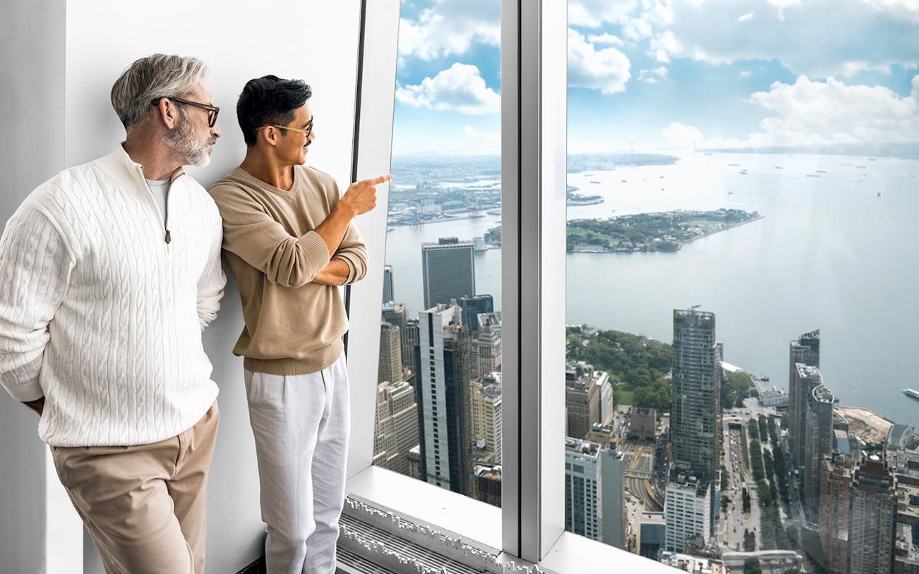 Two people enjoying the view of New York City from One World Observatory.