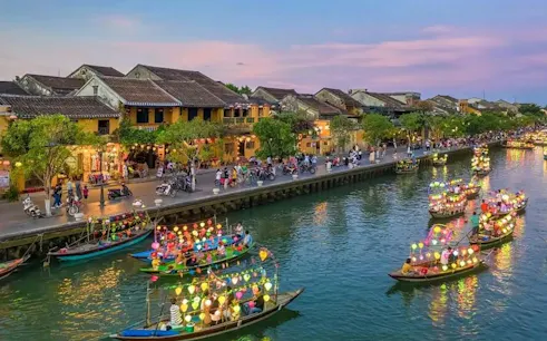 Boat ride with colorful lanterns on a canal, offering free herbal drink, Dubai.