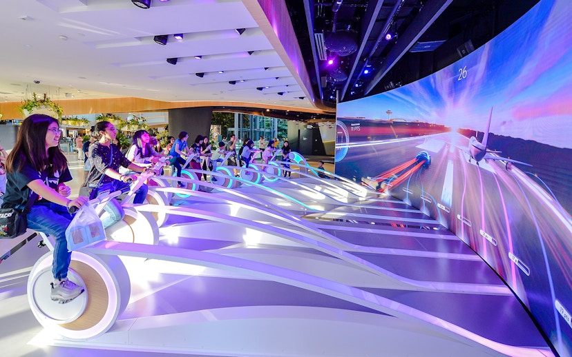 Visitors engaging in interactive experiences at Changi Experience Studio's amazing runway simulation.