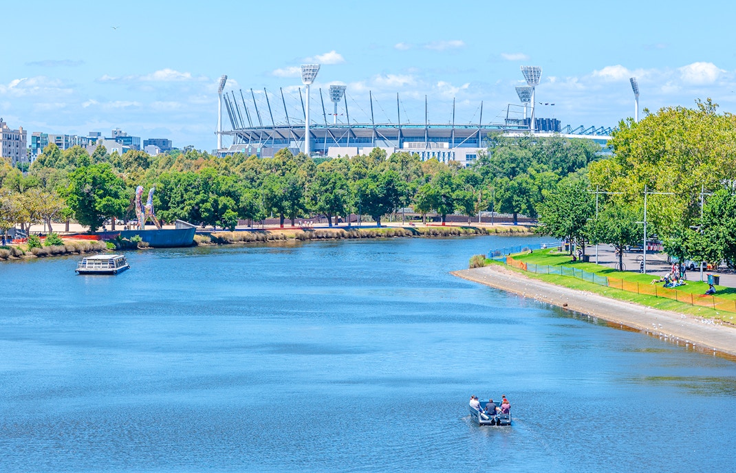 Melbourne Cricket Ground near Yarra River with boats and greenery in Melbourne.