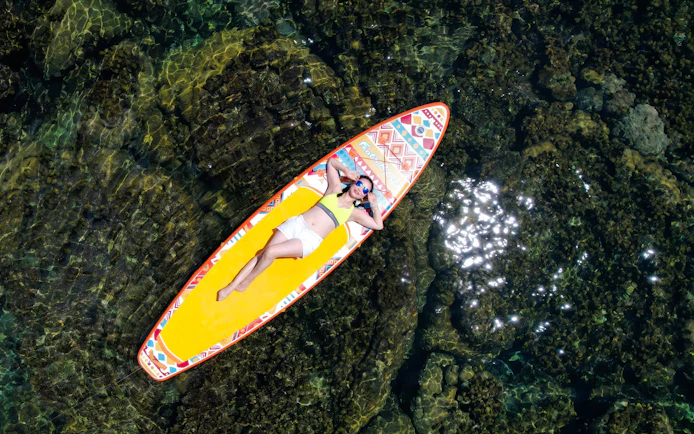 Tourist relaxing on paddle board during 3 Island Hopping Tour in Phu Quoc.