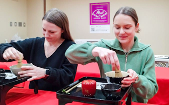 Participants preparing matcha at a tea ceremony in Kyoto's Karasuma area.