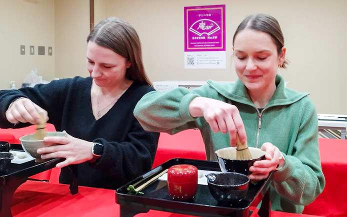 Participants preparing matcha at a tea ceremony in Kyoto's Karasuma area.