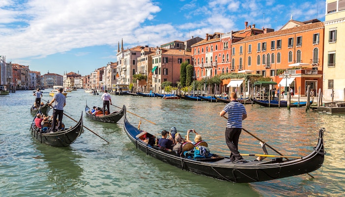 Gondola gliding on Canal Grande with historic Venetian buildings in the background.