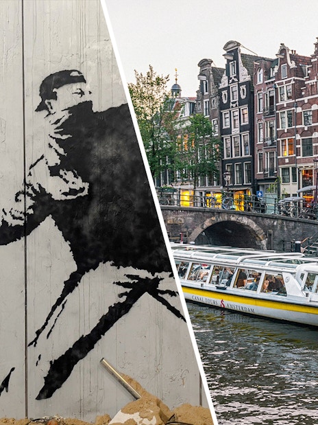 Banksy artwork with flowers and Amsterdam canal cruise boat near historic buildings.