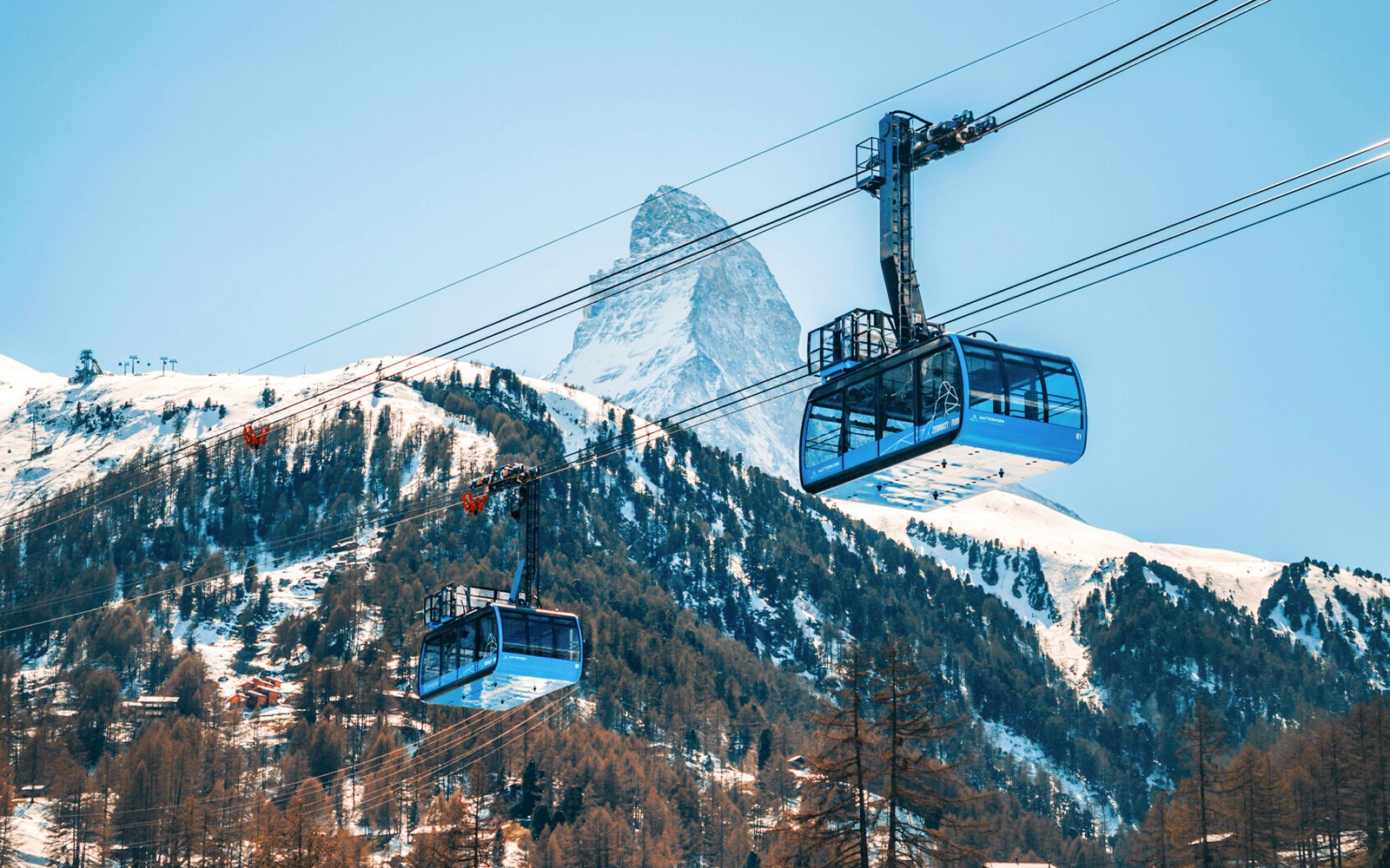 Cable car ascending to Matterhorn Glacier Paradise with snow-covered peaks in Zermatt, Switzerland.