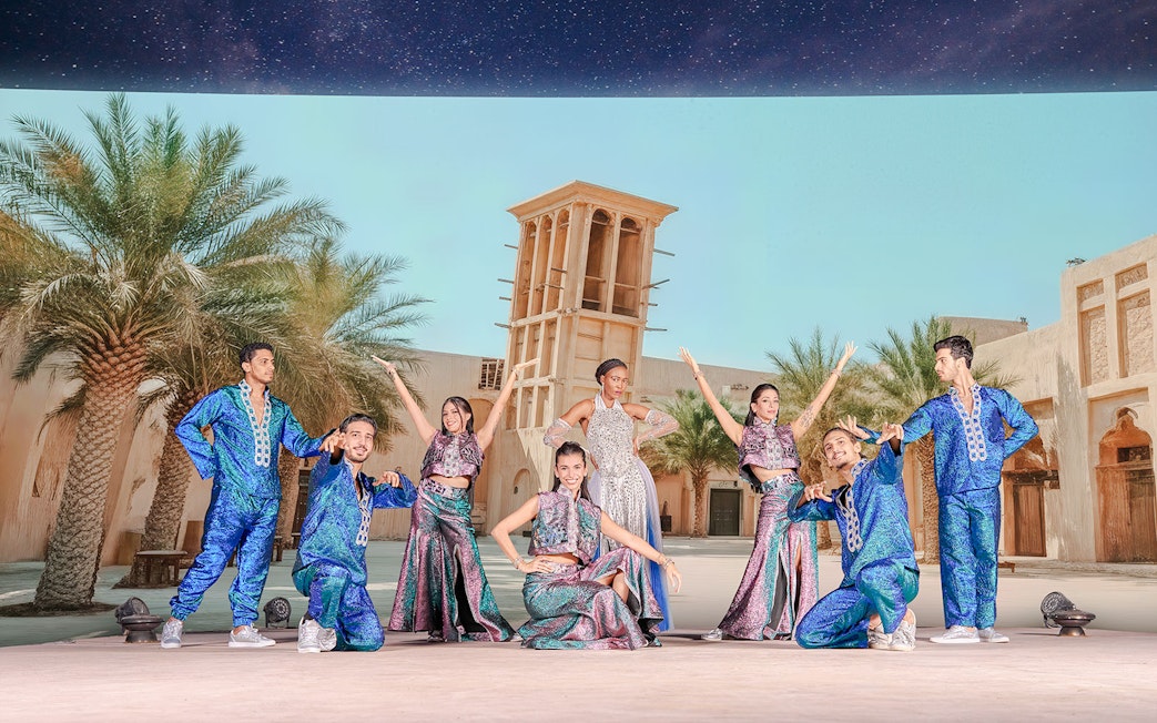 Performers in colorful costumes at Noble Camp Desert Safari live entertainment.
