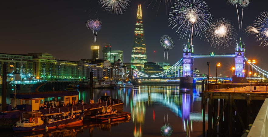 Fireworks over The Shard and Tower Bridge in London at night.