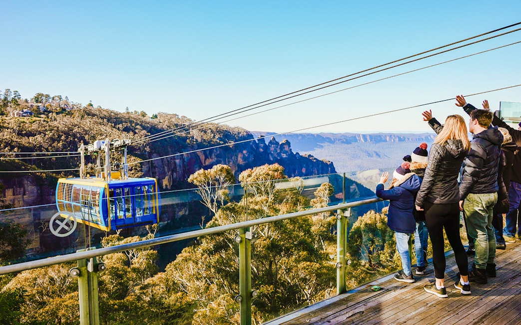 Tourists on a viewing platform watching a cable car in Blue Mountains, Australia.