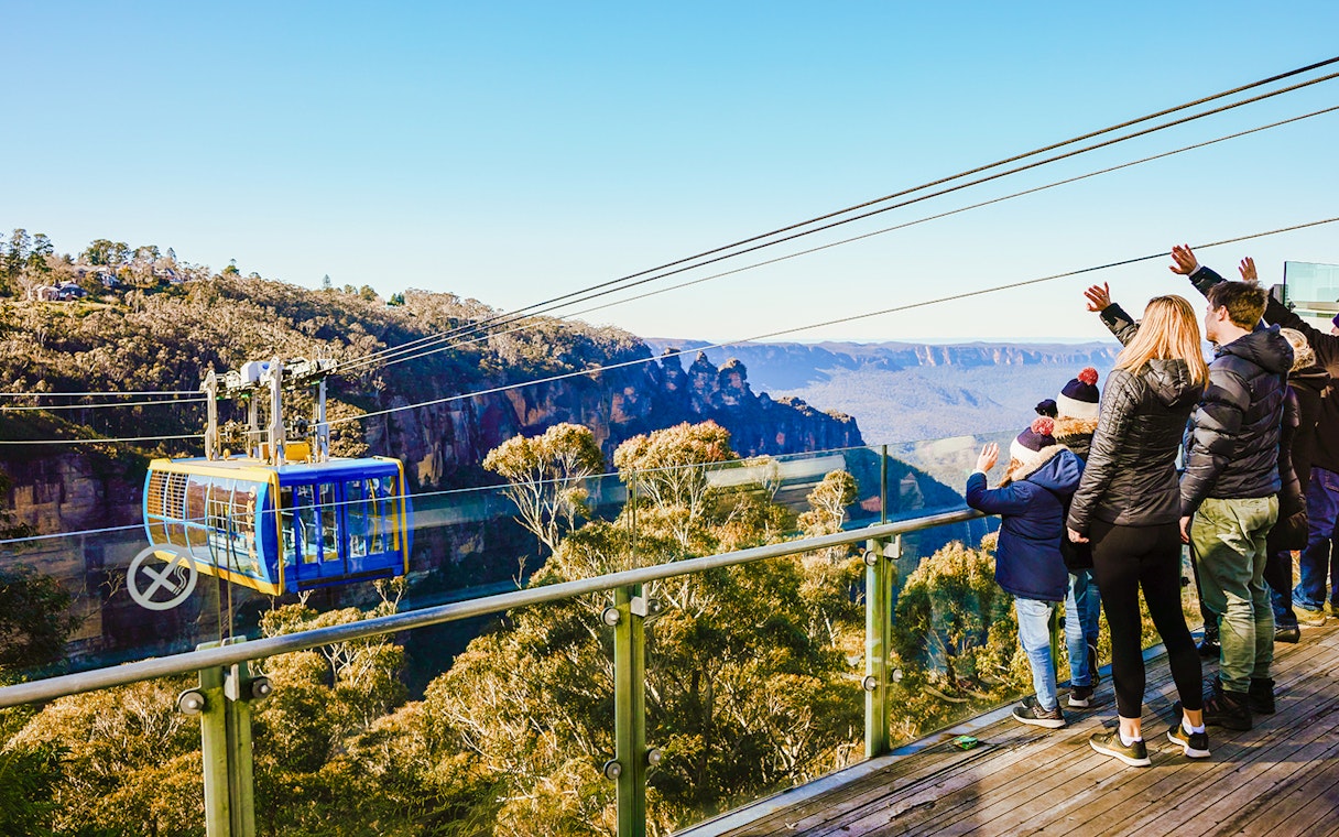 Tourists on a viewing platform watching a cable car in Blue Mountains, Australia.