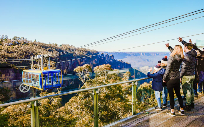 Tourists on a viewing platform watching a cable car in Blue Mountains, Australia.