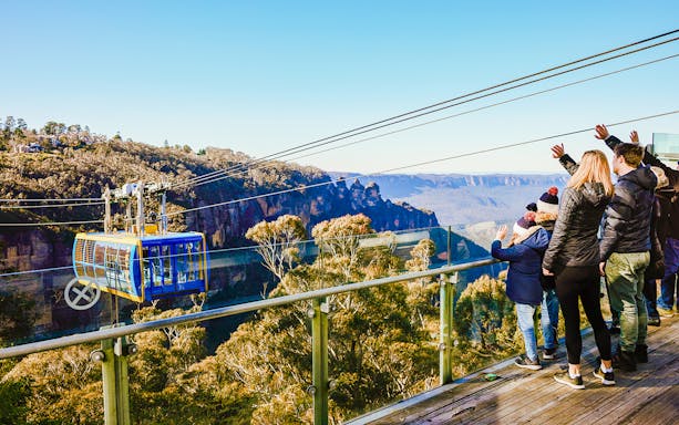Tourists on a viewing platform watching a cable car in Blue Mountains, Australia.