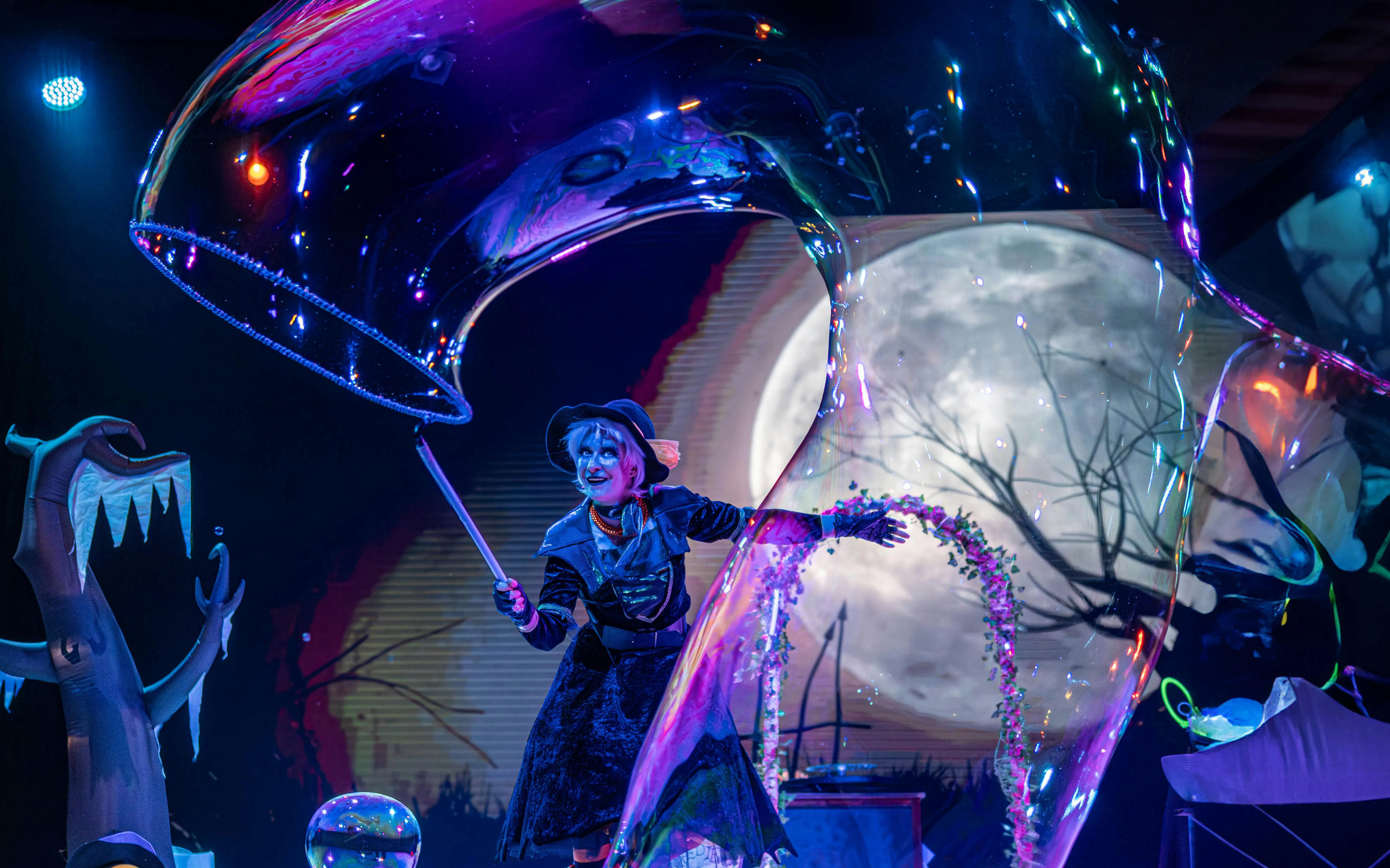 Performer in Halloween costume at PortAventura Park with moonlit backdrop.