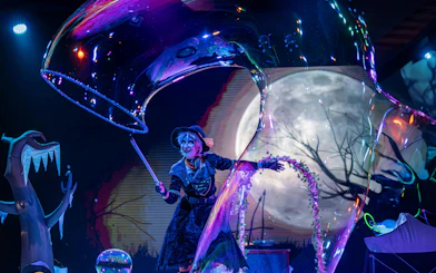 Performer in Halloween costume at PortAventura Park with moonlit backdrop.