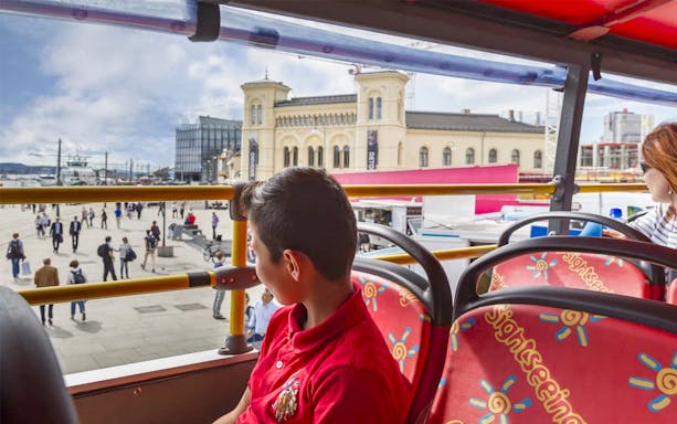 Hop-On Hop-Off bus view of Oslo's waterfront and historic building.