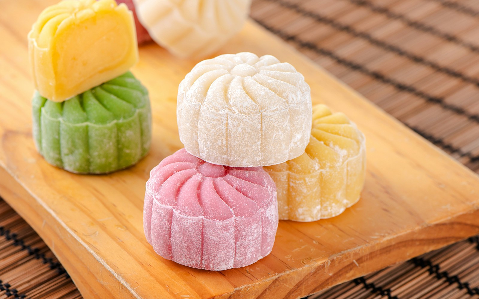 Assorted snow skin mooncakes on a wooden board.