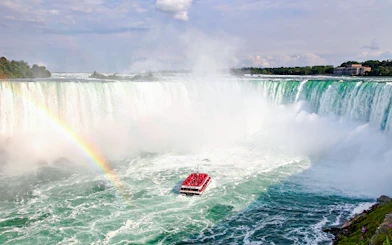 Hornblower Cruise boat near Niagara Falls with rainbow, aerial view, Canada.
