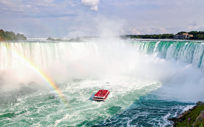 Hornblower Cruise boat near Niagara Falls with rainbow, aerial view, Canada.