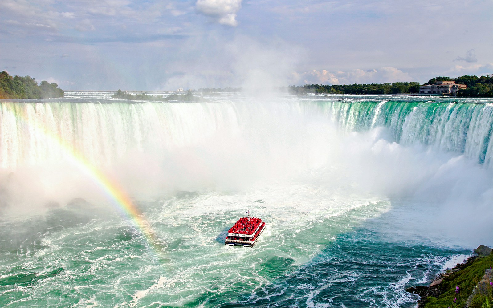 Hornblower Cruise boat near Niagara Falls with rainbow, aerial view, Canada.