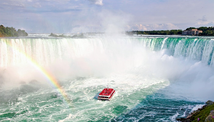 Hornblower Cruise boat near Niagara Falls with rainbow, aerial view, Canada.