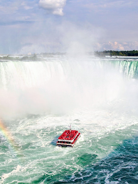 Hornblower Cruise boat near Niagara Falls with rainbow, aerial view, Canada.